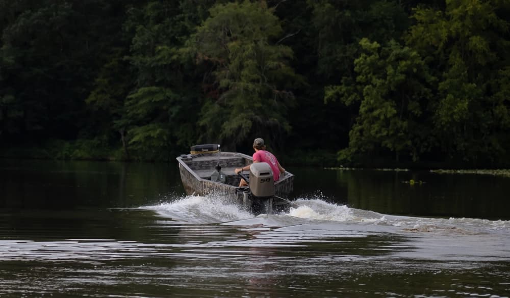 Dusters Outdoors team member boating across the water